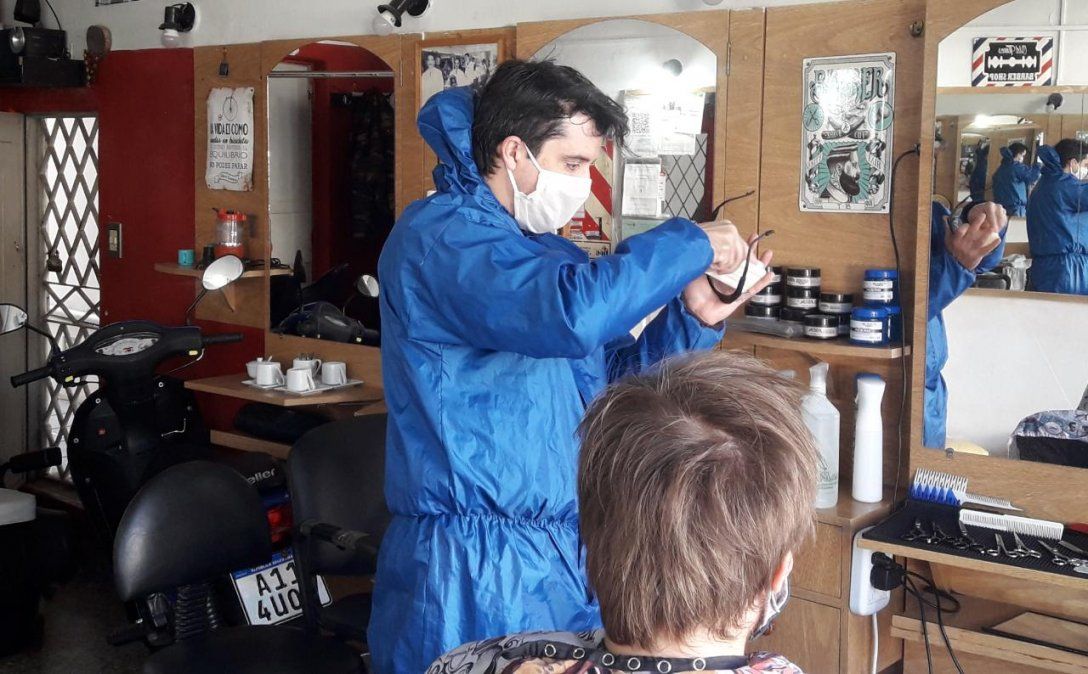 Sebasti&aacute;n, peluquero de Banfield, desinfectando gafas protectoras. Utiliza un traje especial para tener el menor contacto posible con los clientes.