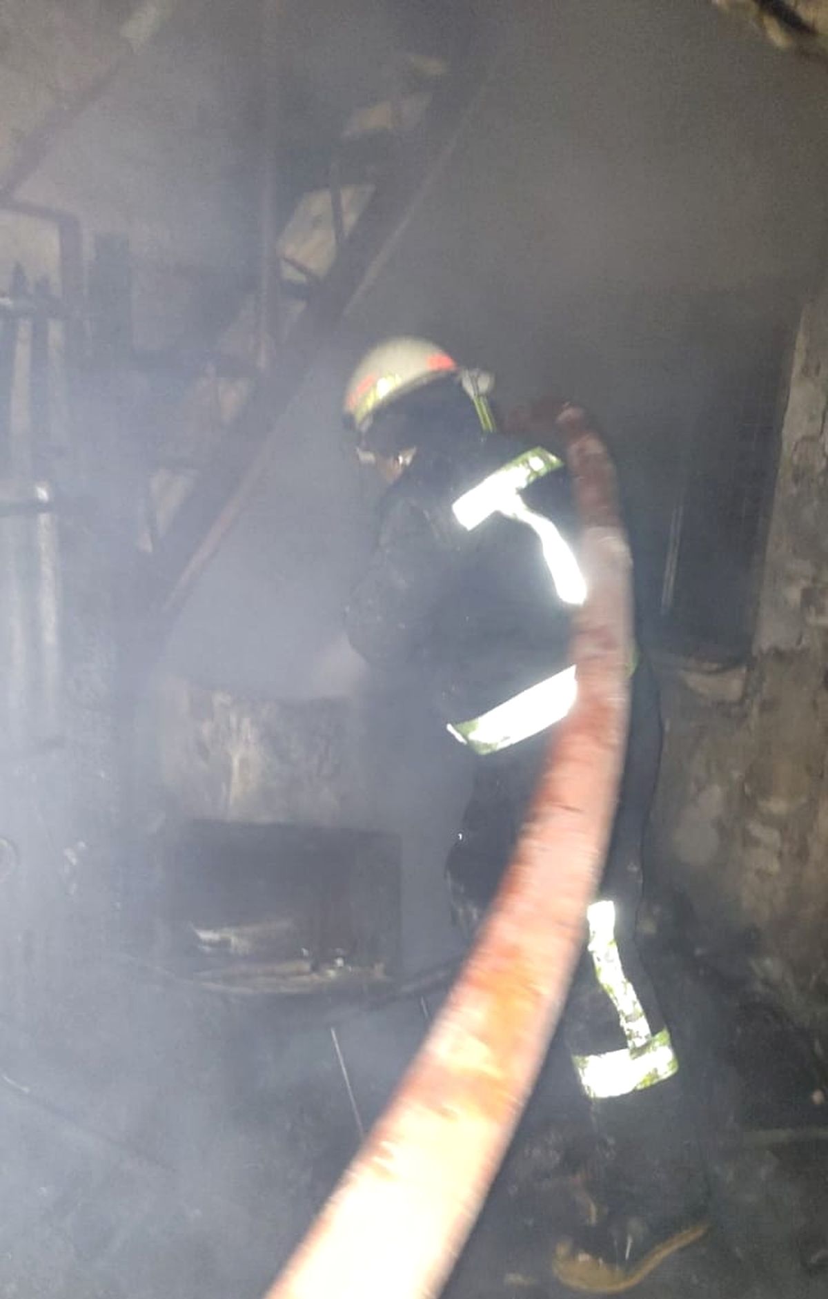 Un bombero combate el incendio dentro de la casa, ya totalmente consumida por el fuego.