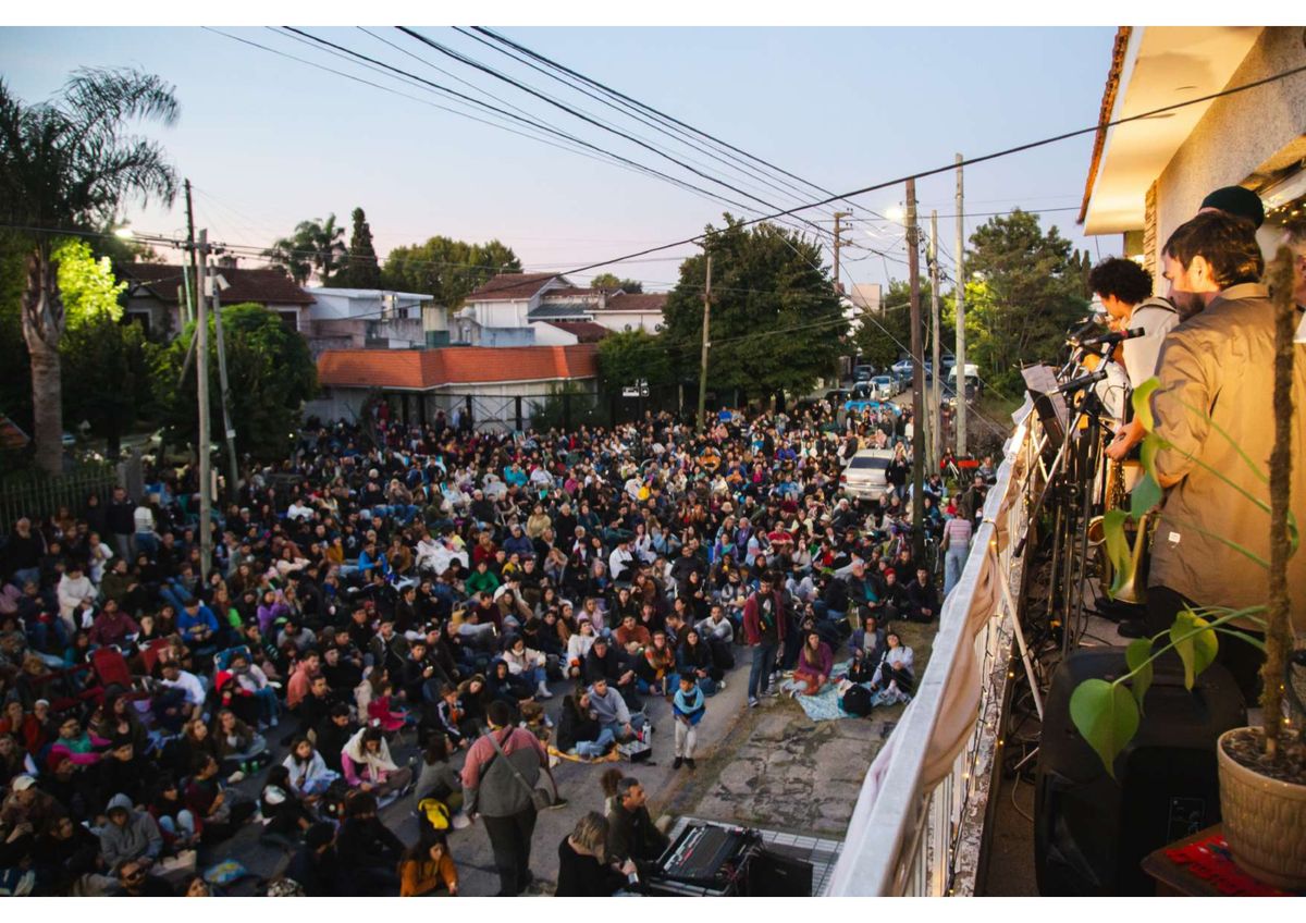 Los integrantes de Música en el Balcón tocan desde lo alto una casa de Temperley mientras vecinos se reúnen en la calle para escuchar el recital.