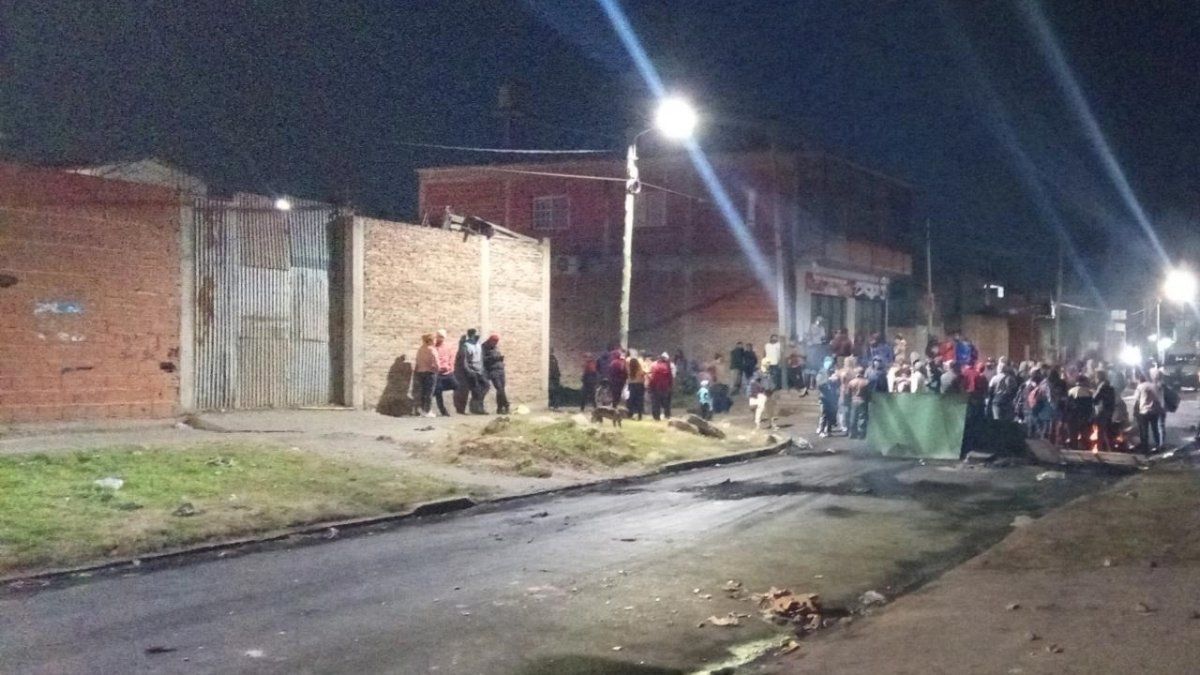 Usurpadores afuera del terreno tras ser desalojados por la Policía.