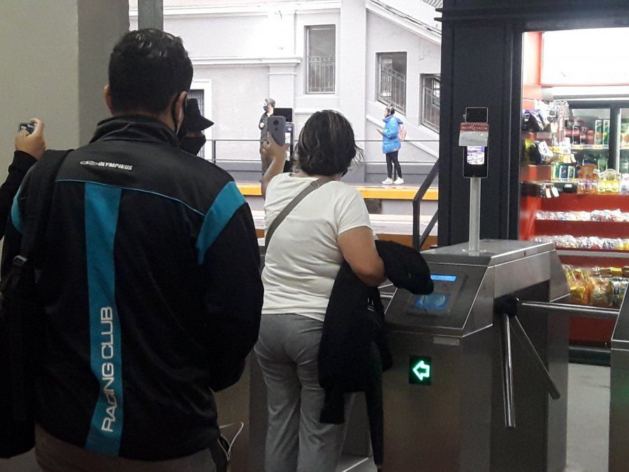 Restricciones en el transporte público: pasajeros escaneando la reserva del tren en Lomas de Zamora.
