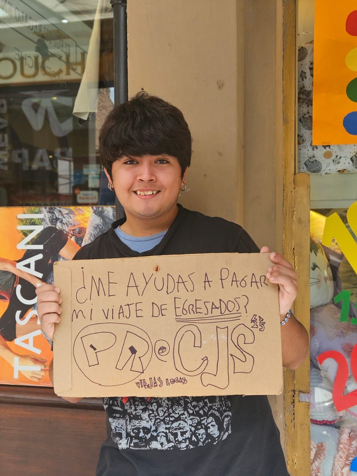 El joven lleva su cartel para pedirle a los vecinos ayuda para pagar su viaje.&nbsp;