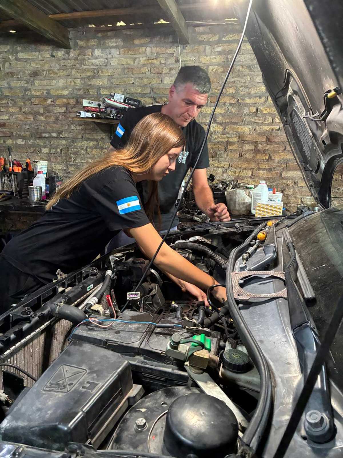 Candela junto a su papá, en su taller familiar ubicado en Burzaco.