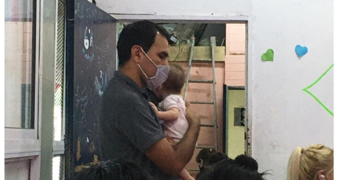 El profesor cuida a la beba en la Escuela 25 de Glew, en Almirante Brown.