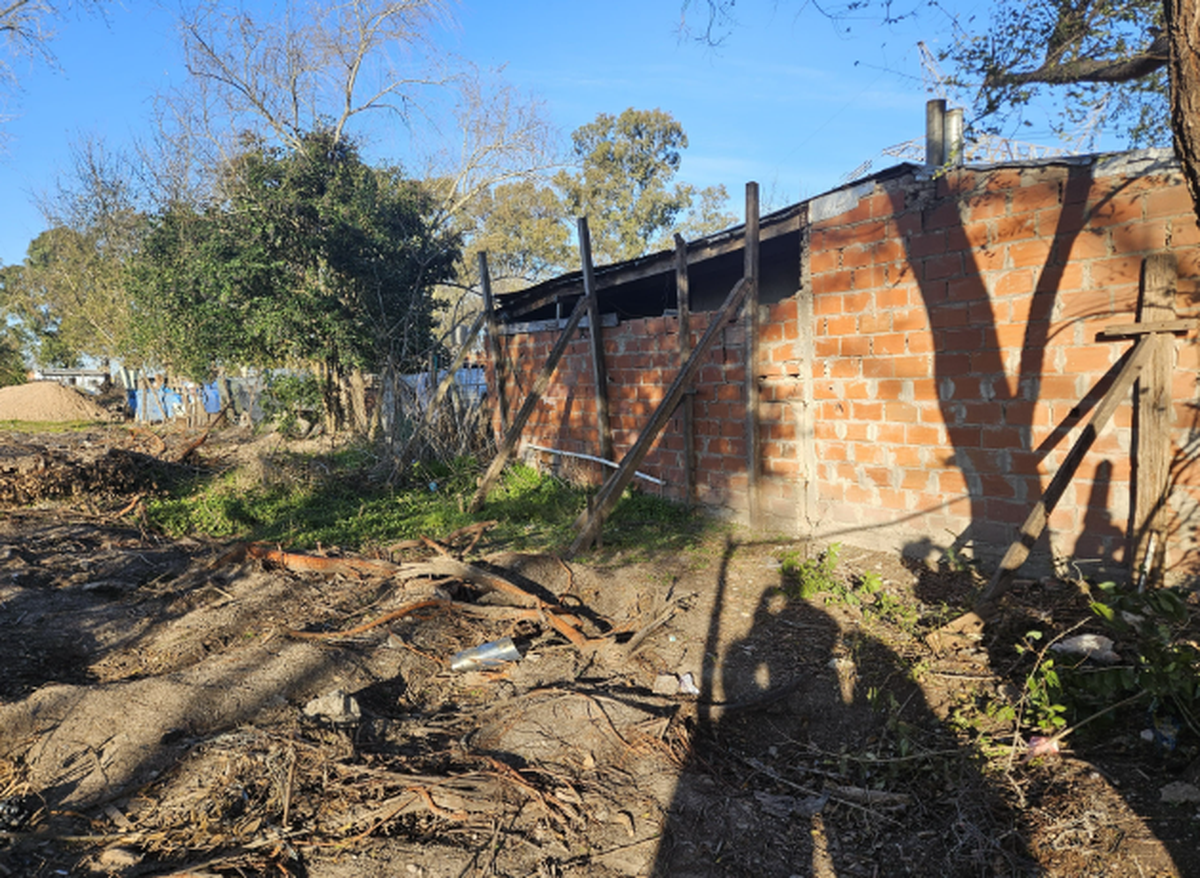 Una casa sostenida por postes de madera en inminente riesgo de derrumbe; allí vive una familia.