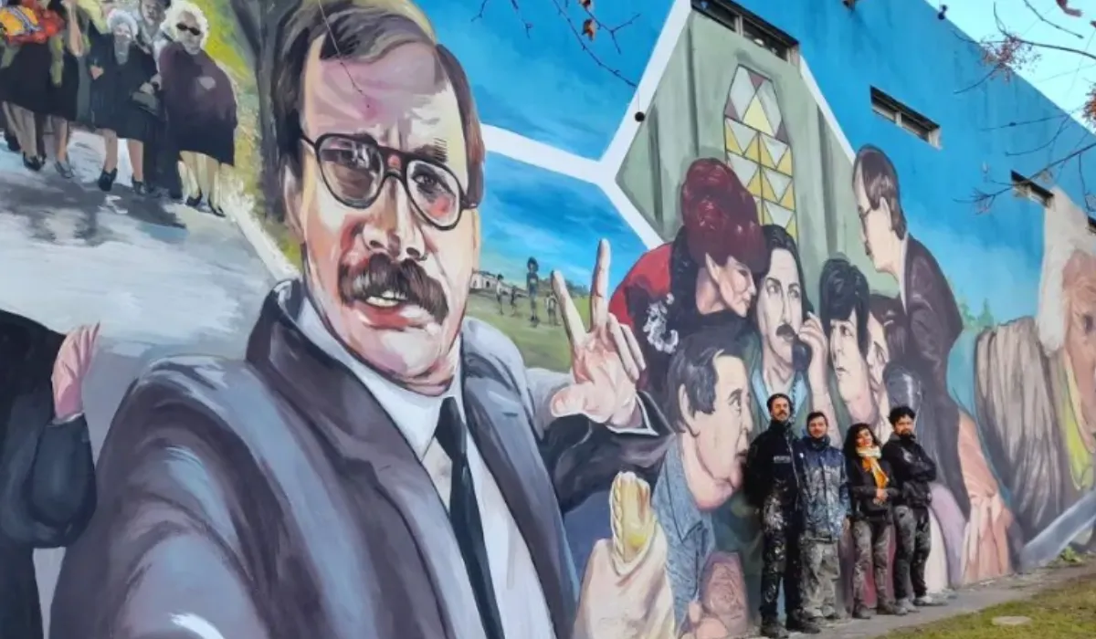 Los artistas junto al mural en 2022. 