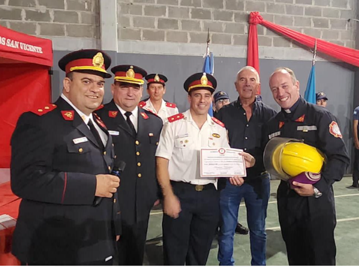 Federico cuando recibió su diploma de bombero de manos del jefe del cuartel, Ariel Bondoni, y el presidente de la institución, Norberto Barciocco.