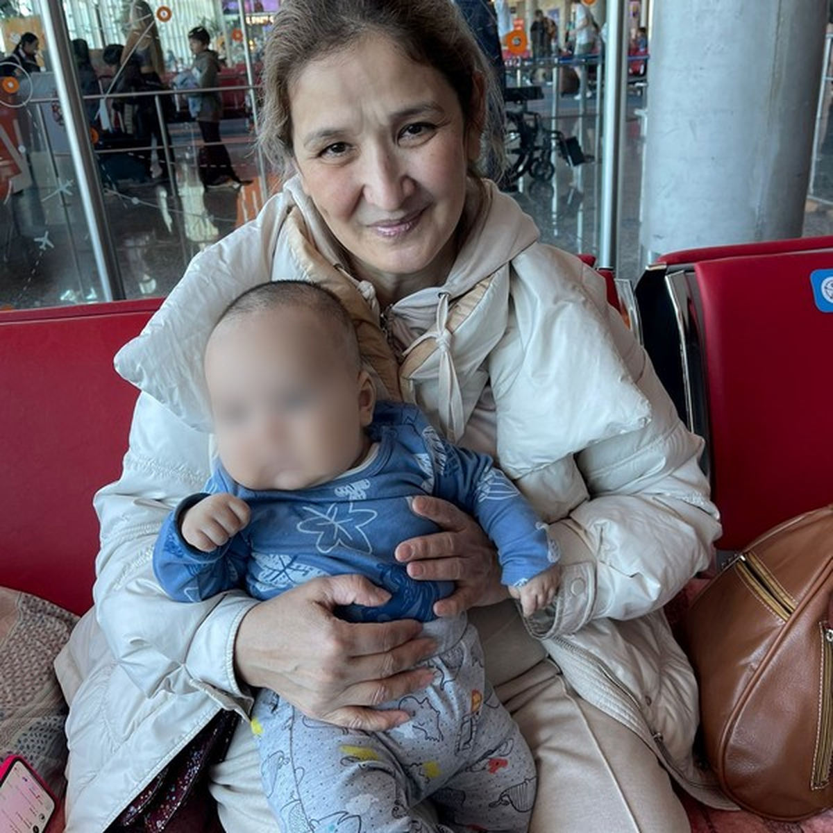 Aigul junto a su nieto en el Aeropuerto de Ezeiza.