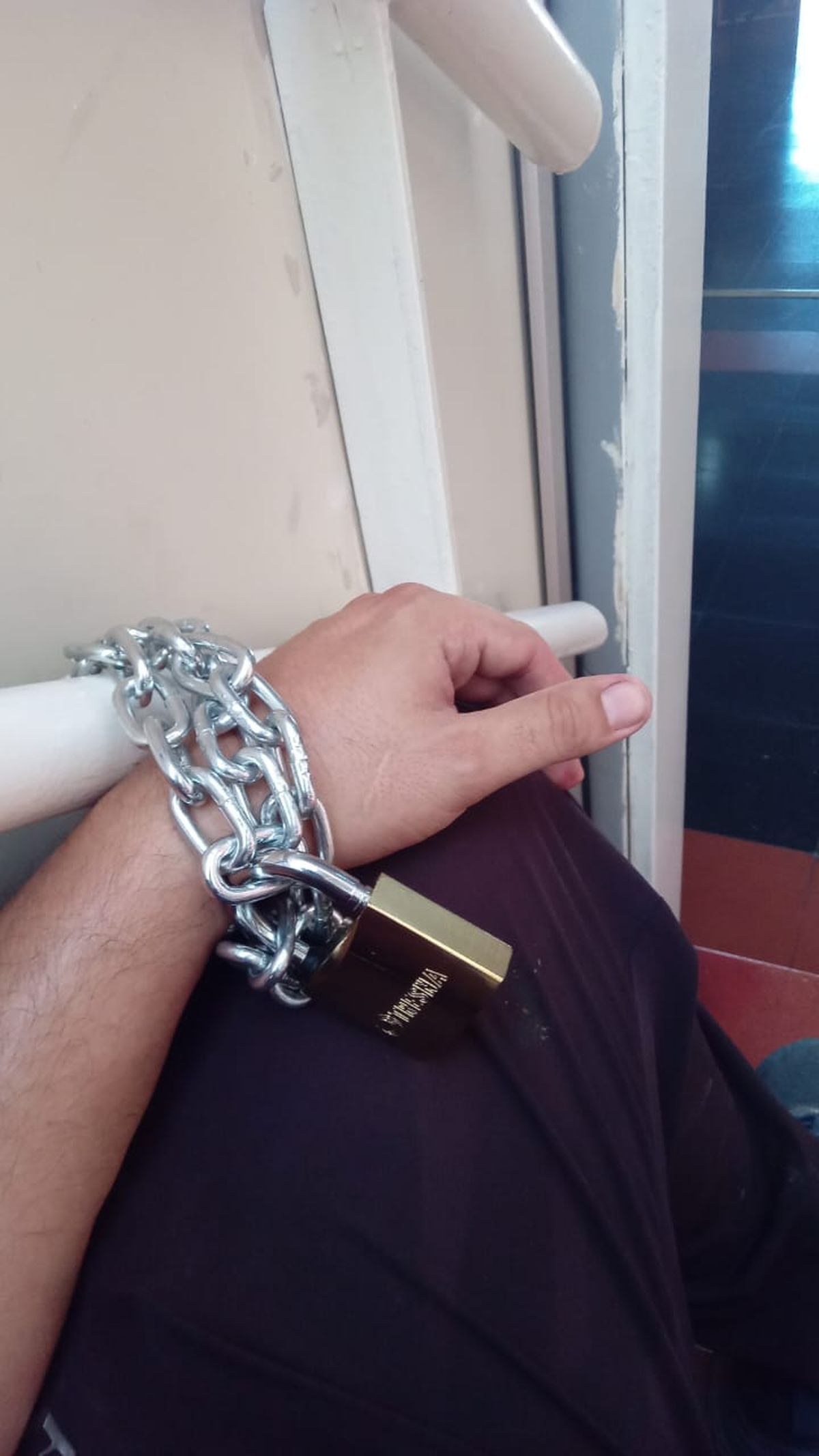 El hombre está encadenado en una escalera de la Municipalidad de Presidente Perón. 