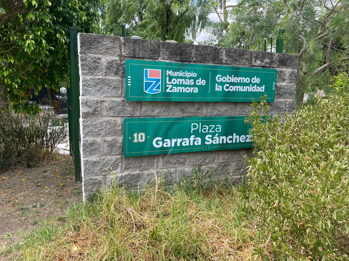 El cartel de la Plaza Garrafa Sánchez, ubicada atras de la cancha del Club Atlético Banfield que lleva el nombre del recordado futbolista y funciona como punto de encuentro del barrio.