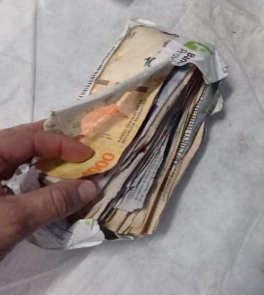 Sobre con dinero y recortes de diario que entregaba el estafador en Lomas de Zamora.